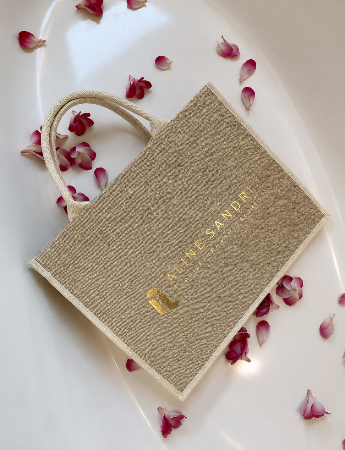 Bolsa em tecido natural com a marca Aline Sandri e pétalas ao redor